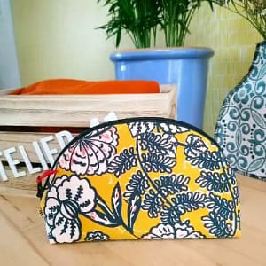 Photo de la trousse demi-lune, avec motif à fleur et fermeture éclair sur la partie courbée